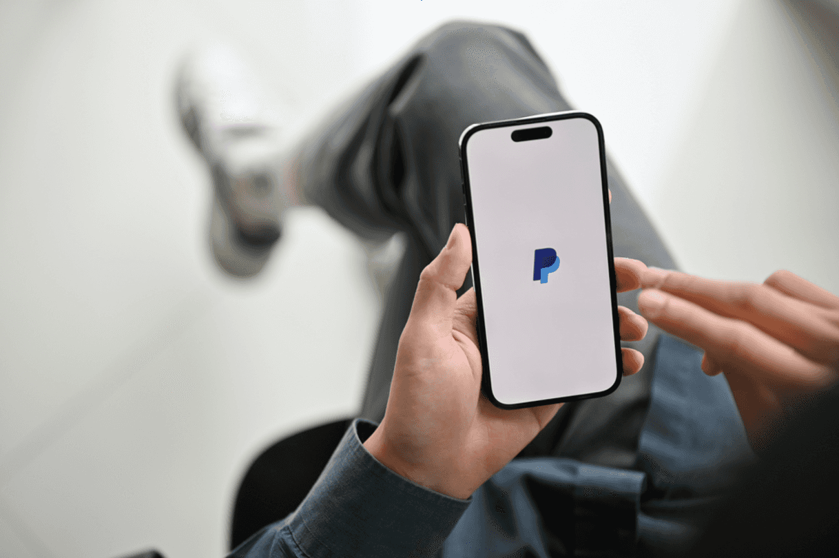 Image showing an individual using PayPal on an iPhone.