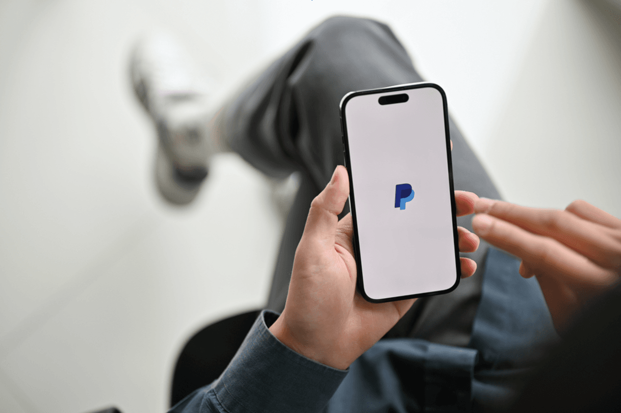 Image showing an individual using PayPal on an iPhone.